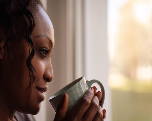 Person drinking water and looking out the window